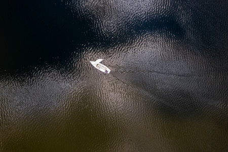 Aerial view of a small boat floating on the water surface.の写真素材