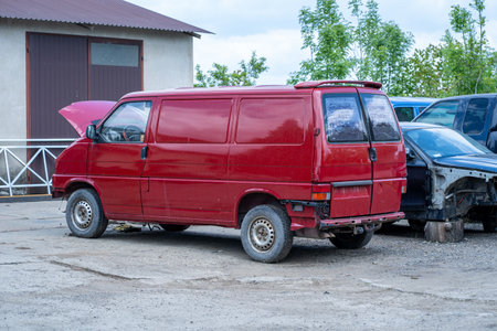 The old red van is parked on the street near the house.の写真素材