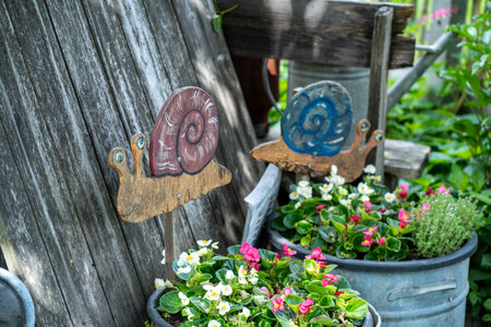 Wooden signboard with snail and flower pot decoration in the gardenの写真素材