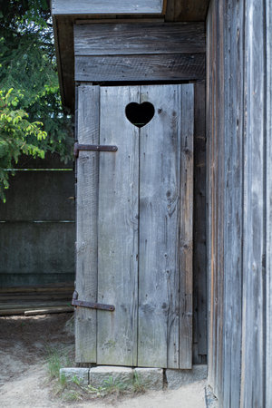 Old wooden door with a heart-shaped hole in the middle.の写真素材