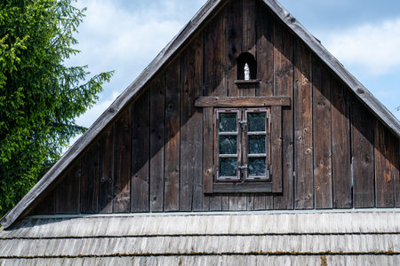 Old wooden house with a window on the roof of the house.の写真素材