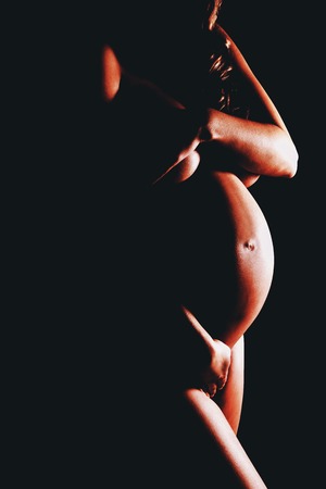 Naked pregnant woman covering her breastの写真素材