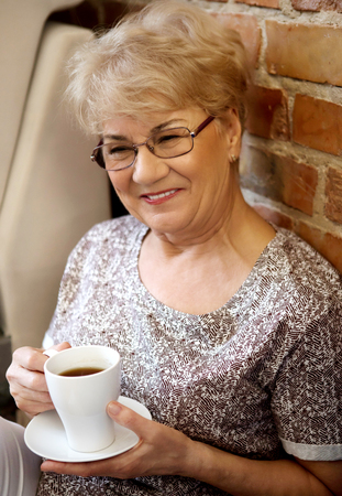 Smiling senior couple drink coffee or teaの写真素材