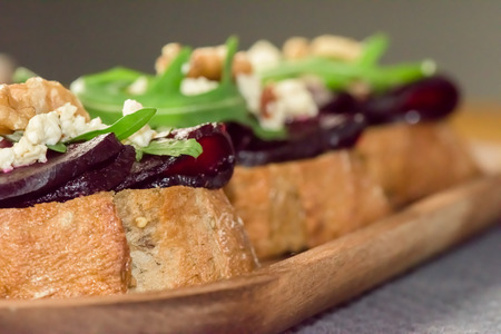 Slices of bread with roasted beetroot on dark background - healthy vegetarian food- close up, macro shotの写真素材