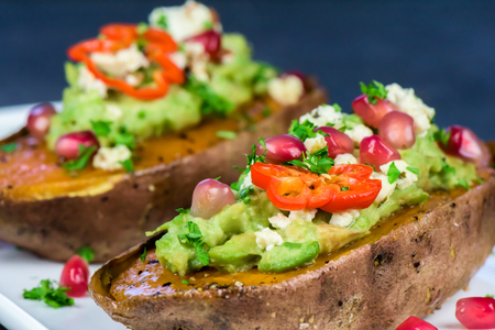 Healthy food - Baked sweet potatoes with guacamole, pomegranate - closeupの写真素材