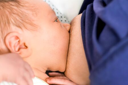 Mother is breast-feeding her little baby