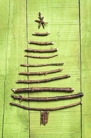 Christmas tree arranged from sticks, twigs, driftwood on wooden green background.の写真素材