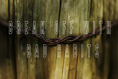 Sentence break off with bad habits written on natural wooden background with metal wire in a middle.