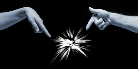 Man and woman hands pointing on incomprehensible light on black background.の写真素材