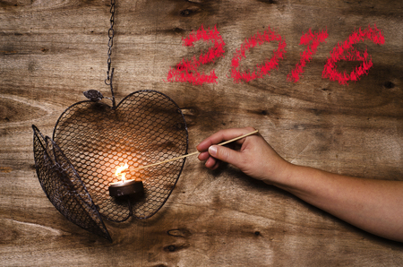 New year 2016 written on wooden background. Lighting the heart.の写真素材