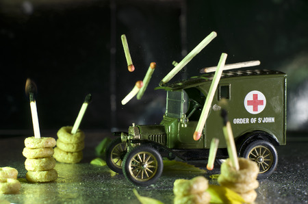 Green toy ambulance with red cross on it.