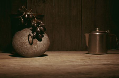 Coffee percolator, black grapes on wooden table, copy space.の写真素材
