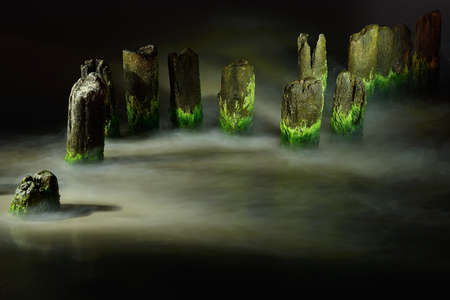 Old ruined breakwater on the beach at night, Ustka, Poland, Baltic sea.の写真素材
