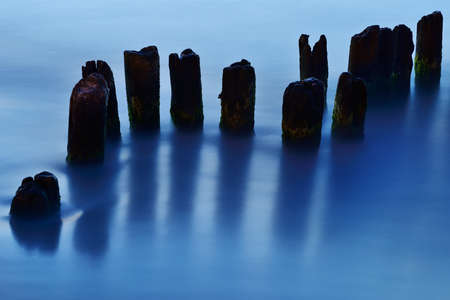 Broken breakwater on the beach at night, Ustka, Poland, Baltic sea.の写真素材