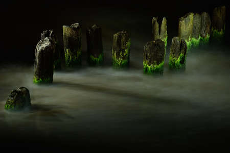 Old breakwater on the beach at night, Ustka, Poland, Baltic sea.の写真素材