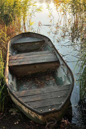 Old vintage fishing boat on lake shore. Taken at late evening.の写真素材