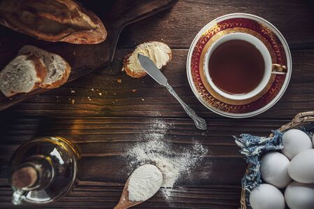 Wood table with bread sliced and a cup of tea