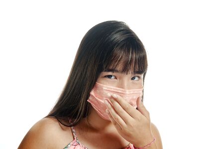 Asian girl wearing mask, coughing and looking to the cameraの写真素材