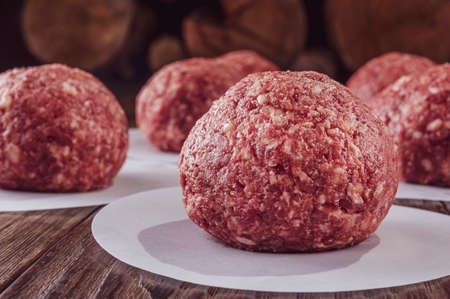 Ground beef balls for hamburger with wood pile background - Close-upの写真素材