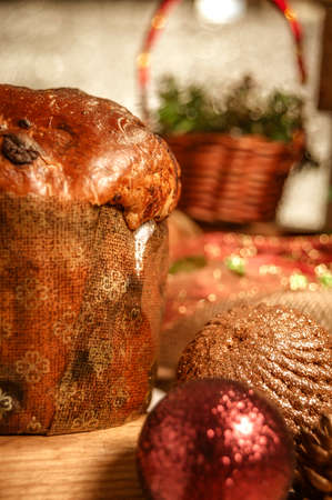 Chocolate panettone on wooden table with christmas ornaments