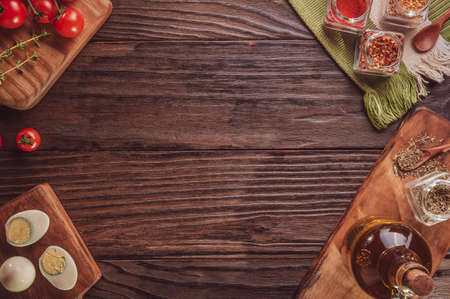 Top view of table with tomato, boiled eggs, olive oil, oregano and ingredients with space to pizza...