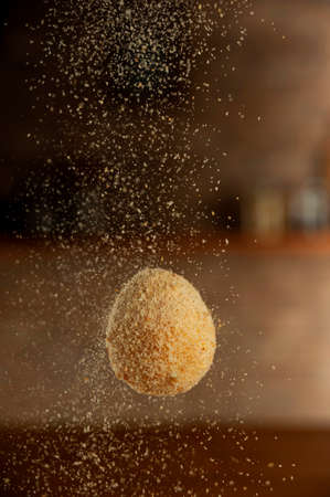 Uncooked Brazilian croquette stuffed with cheese been breading with breadcrumbs.の写真素材