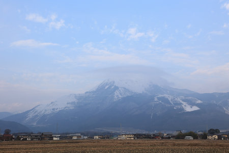 Small village, with mountain in the background covered with a thin bluish haze.の写真素材