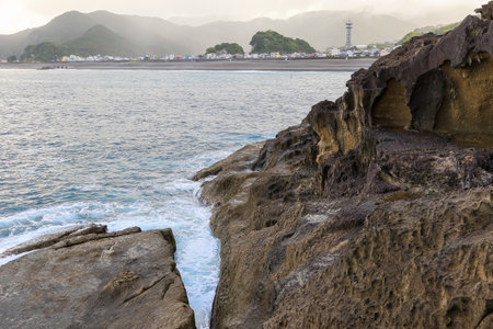 Rocks and a small village on the beach.の写真素材