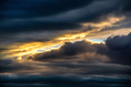 Fantastic cloudy sky with sunbeams breaking through the clouds