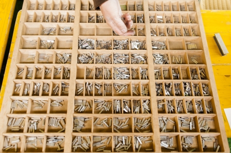 Sorting single letters into a box for a vintage printing press