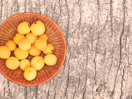 Ripe apricots in a basket on a wooden background.の写真素材