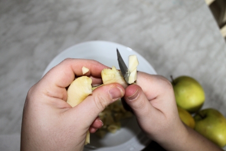 female hands intent on cutting an appleの写真素材