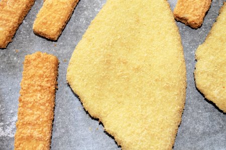 breaded fish on baking paperの写真素材