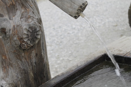 typical wooden fountain in the high mountainsの写真素材