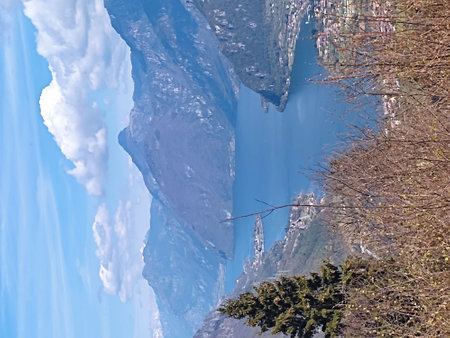 A view of the frozen lake in the Alps. The blue sky and white clouds are reflected in the water.