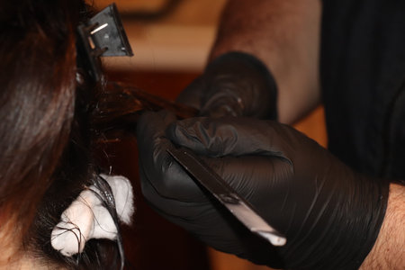Professional hairdresser cutting hair of woman in salon, closeupの写真素材