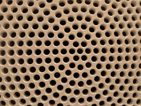 abstract background of a brown perforated metal panel with holesの写真素材