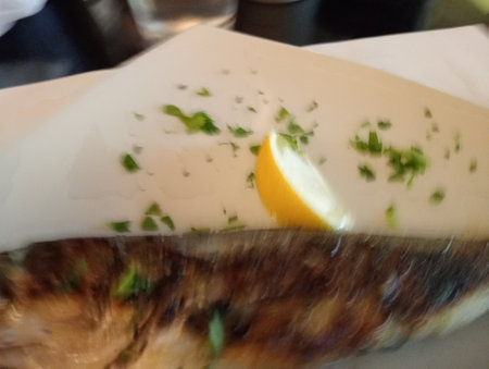 Close-up of a piece of fish with lemon and parsley