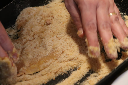 Woman kneads dough in a baking dish, close-up