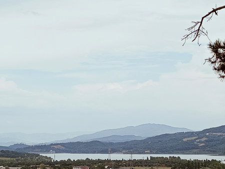 Landscape with a lake, hills, trees and blue sky.の写真素材
