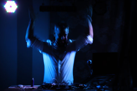 DJ playing music at night club in dark room with lights and smoke