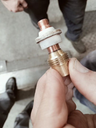 Two men hold a plumbing connector in their hands. Close-up.の写真素材
