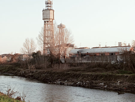 Abandoned water tower on the bank of a small river.の写真素材