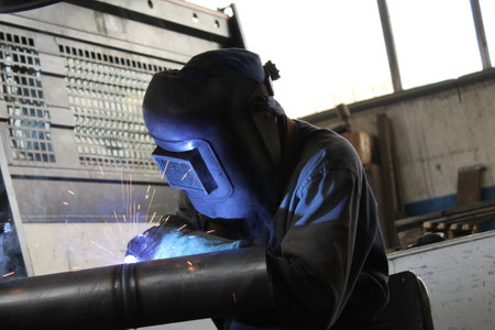 welder at work in a factory,worker in protective clothing welding