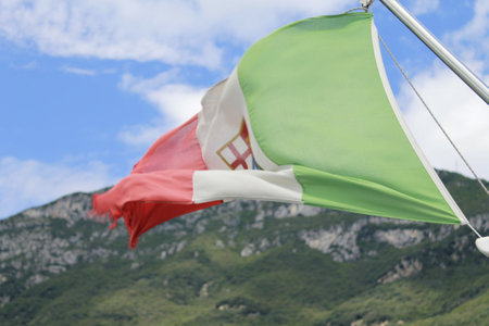 Flag of Italy waving in the wind on a background of mountains.の写真素材