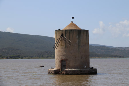 Old windmill on the bank of the riverの写真素材
