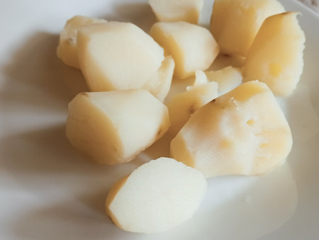 Peeled potatoes on a white plate, close-up, selective focusの写真素材