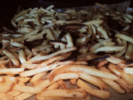 French fries in a paper bag on the table. Toned.