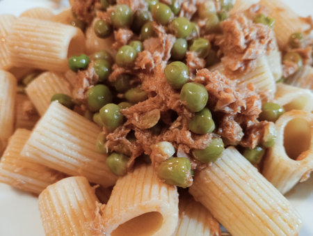 close up of penne pasta with tuna and peas on white plateの写真素材
