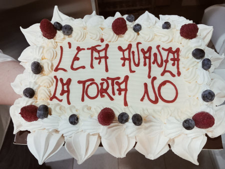 Birthday cake with a message written on it and decorated with berriesの写真素材